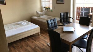 Huoneessa on sänky, työpöytä ja kaksi tuolia.
