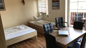 Ein Zimmer mit einem Bett, einem Schreibtisch und zwei Stühlen.