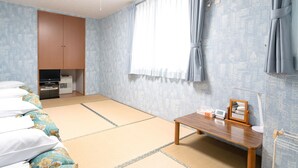 A room with tatami mats, a wooden table, a TV, and a wardrobe. - Pension Setsurin (Sapporo)