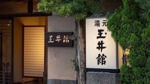 A building entrance with a sign that reads '湯元王宮館' and another sign with '土井館'.