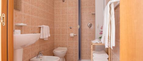 A bathroom with a sink, toilet, and shower.