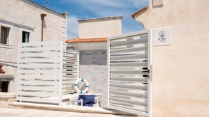 A white gate with a sign reading "AL FARO" and a lifebuoy on the ground. - Al Faro Guest House (Vieste)