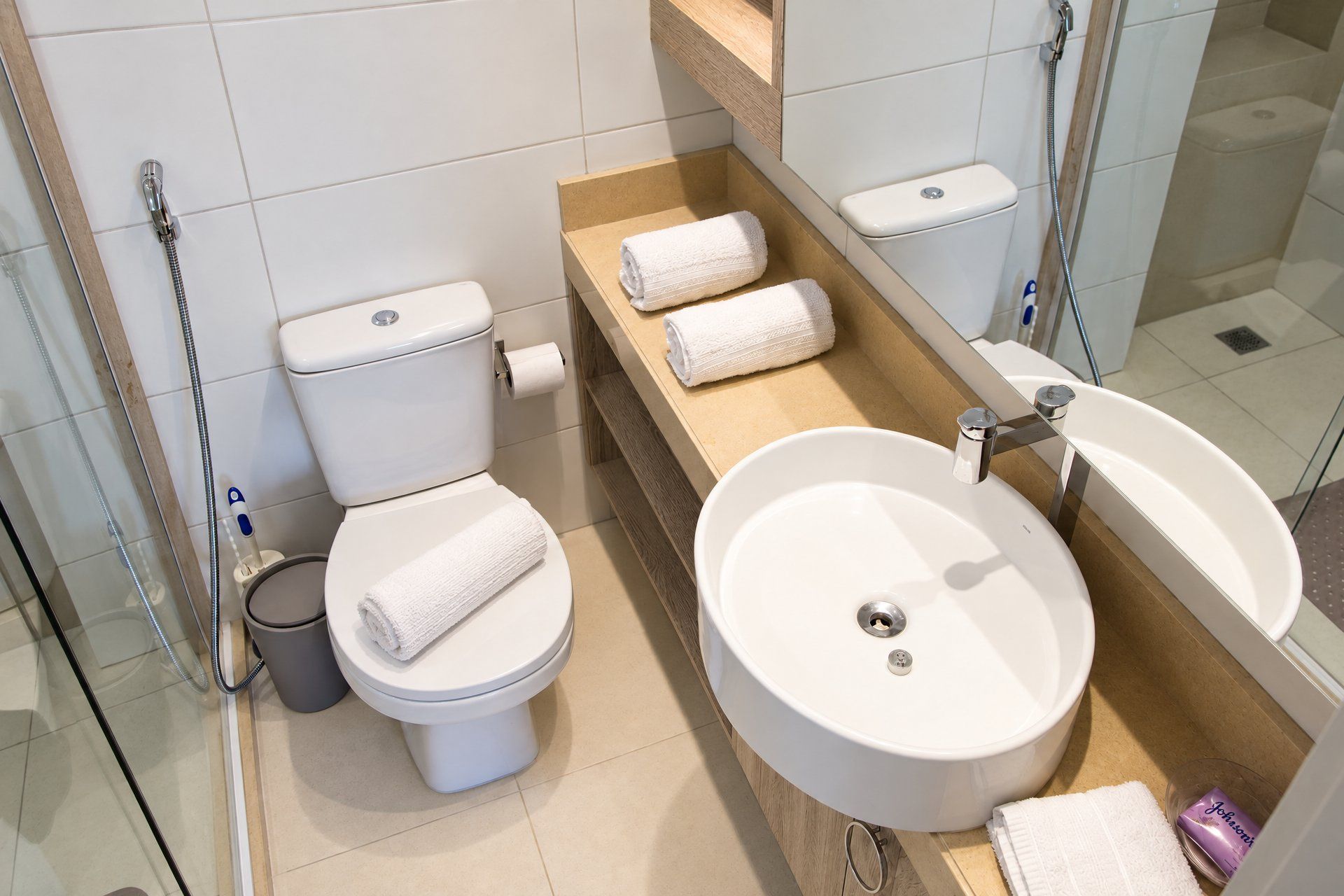 Un baño moderno con inodoro, lavamanos y ducha.