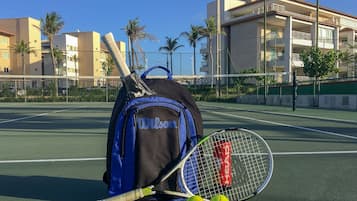 Una cancha de tenis con una bolsa, una raqueta y pelotas, todo con la marca Wilson.