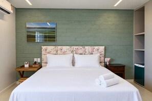 A hotel room with a bed, a nightstand, a wall-mounted painting, and a wardrobe. - Penthouse Apartment with Hot Tub near Beach (Aquiraz)