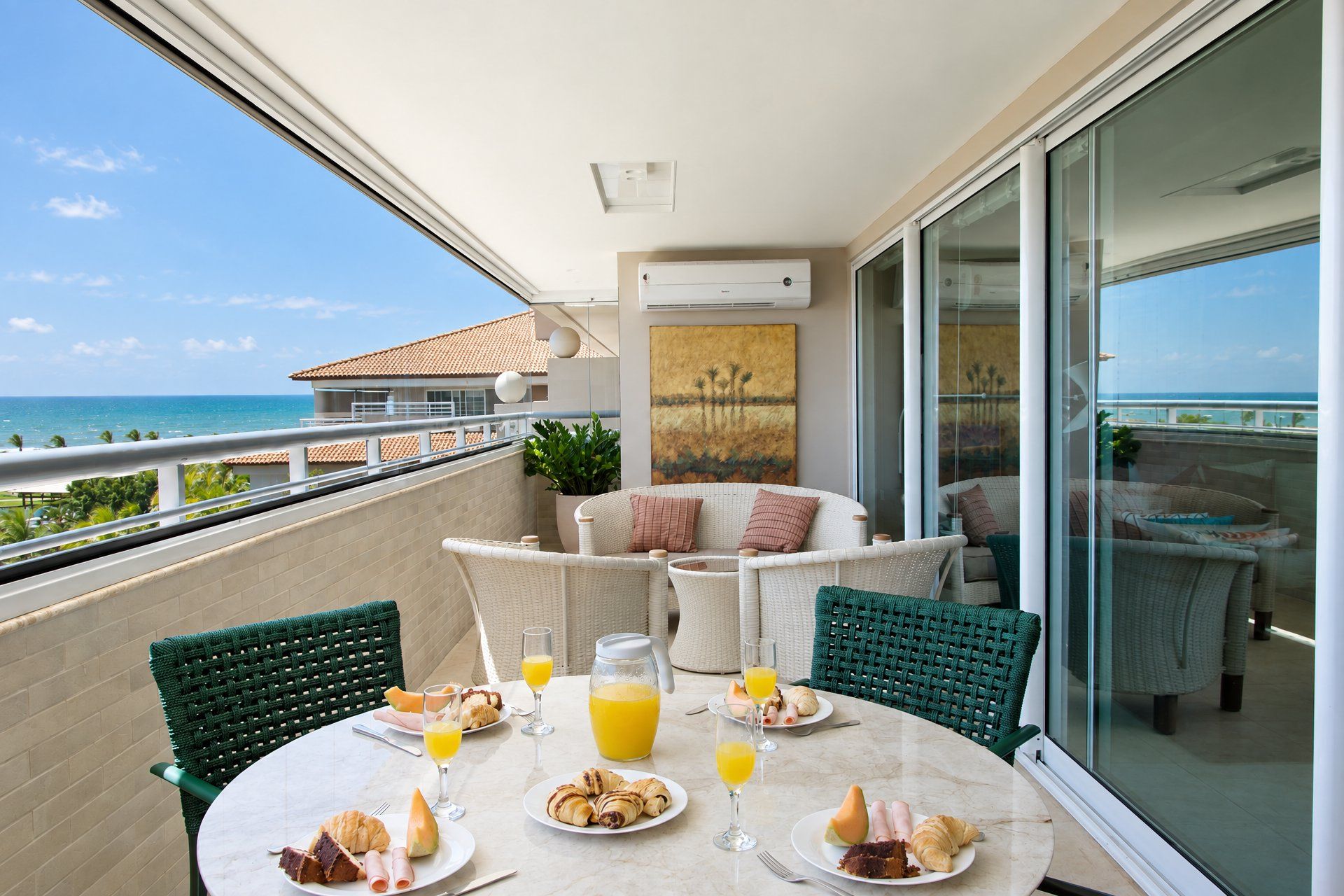 Un balcón con una mesa dispuesta para el desayuno, con vista al mar.