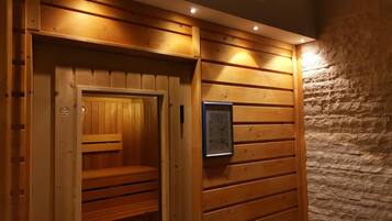 Un sauna aux murs en bois, avec un banc à l’intérieur.
