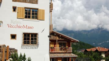 A building with a sign reading "Relais VecchioMaso" and a balcony with flowers.