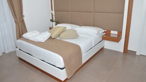 Una cama bien hecha con estructura de madera, una mesita de noche y una lámpara de pared.