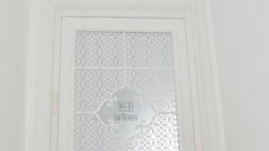 Una puerta blanca con un panel de vidrio decorativo y una placa que dice "B&B La Movida".