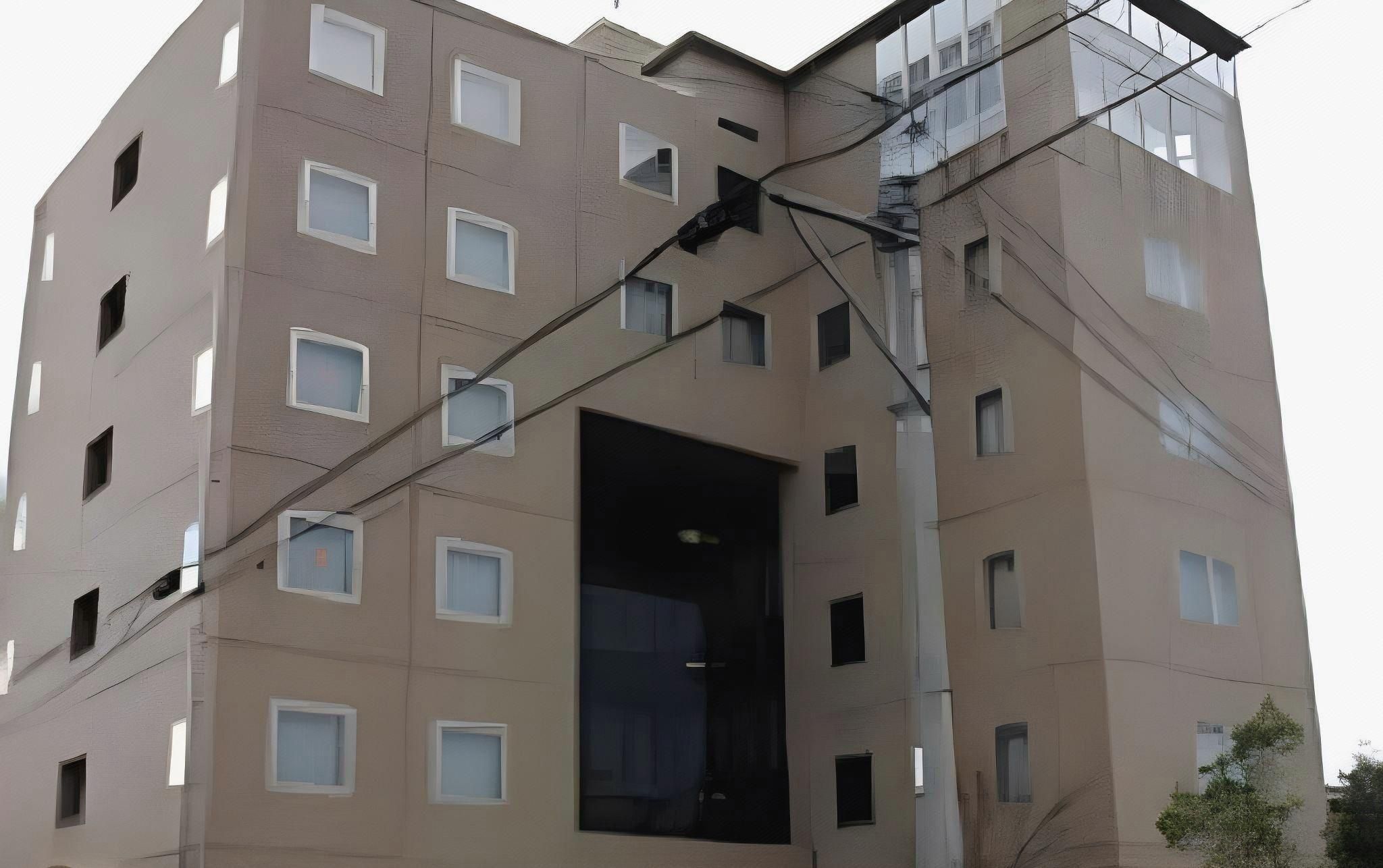 A multi-story building with a central open space, multiple windows, and visible electrical wiring.