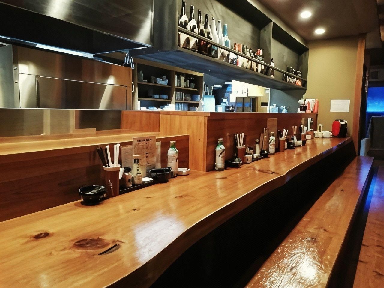 Uma área de bar com um balcão de madeira comprido, prateleiras com garrafas e diversos utensílios de bar.