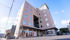 Ett hotell med flera våningar och modern design, med en stor entré av glas och många fönster.