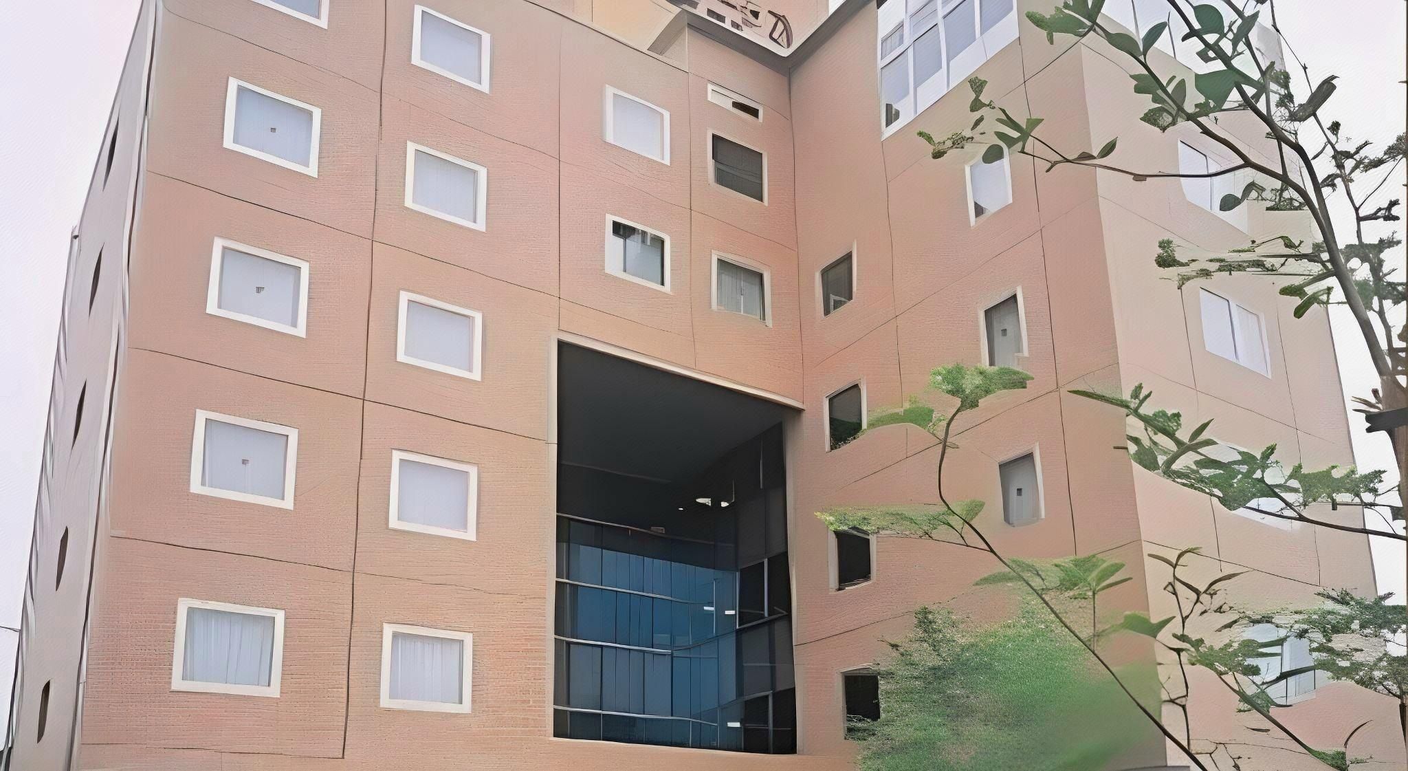 A multi-story building with a central open space, possibly a lobby or atrium, and multiple windows on each floor.
