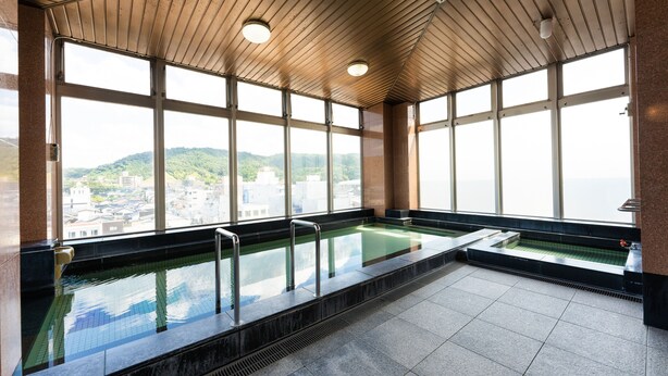 En pool med utsikt över staden, stora fönster och ett tak i trä.
