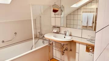 A modern bathroom with a glass-enclosed shower, a white sink with a mirror above, and a toilet.