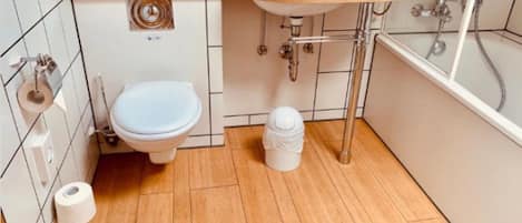 Un baño pequeño con inodoro, lavamanos y ducha.