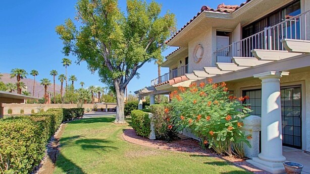 A two-story building with a covered patio, palm trees, and a well-maintained lawn. - Villa Antonella (Palm Springs)