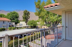 A balcony with a view of a mountainous landscape, a white door, and a red-tiled roof. - Villa Antonella (Palm Springs)