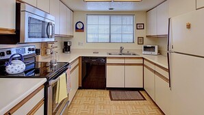 A compact kitchen with a microwave, stove, dishwasher, and a small sink. - Villa Antonella (Palm Springs)