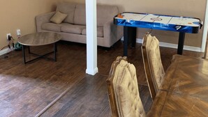 Un salon avec une table de billard, un canapé et une table basse.