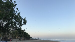 A beach with a sign for 'La-Dorga Beach Bar' and a few people in the distance. - Kubu Willis (Legian)