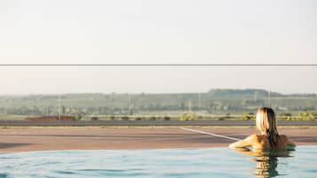 Une personne dans une piscine, avec une vue sur un paysage lointain.
