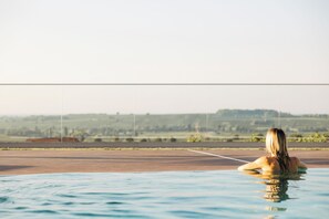 A person in a swimming pool with a view of a distant landscape. - Leinsweiler Hof (Leinsweiler)