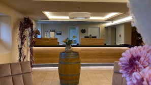 Welcome to our reception area, featuring a comfortable seating area with a vase of flowers and a large barrel.