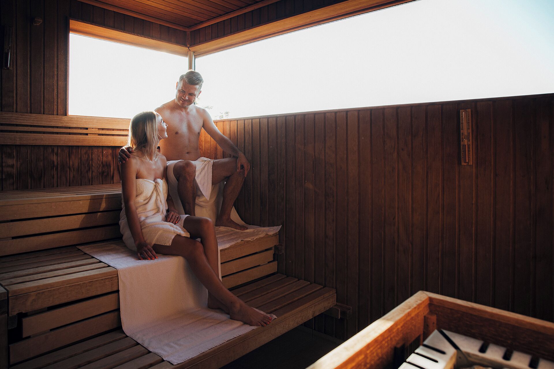A wooden sauna with benches and a bench with a towel.