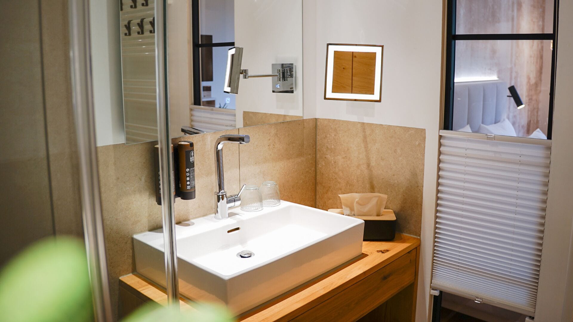 Une salle de bain moderne avec un grand lavabo, un miroir et un porte-serviettes.