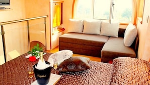 A cozy room with a sofa, a small table with a vase and a glass of wine, and a large window with a view of the outdoors. - Apartments Salu (Medulin)
