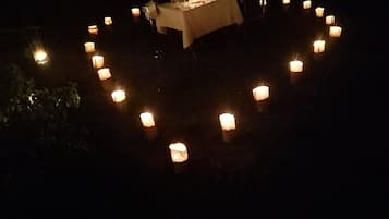Velas dispuestas en círculo sobre una mesa con mantel, evocando un ambiente romántico o íntimo.