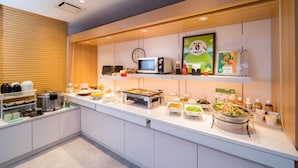 A buffet setup with various food items and a microwave. - Super Hotel Takamatsu Kinenkan (Takamatsu)