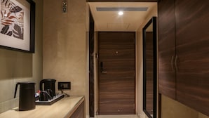 A hallway with a wooden desk, a framed picture, and a door at the end.