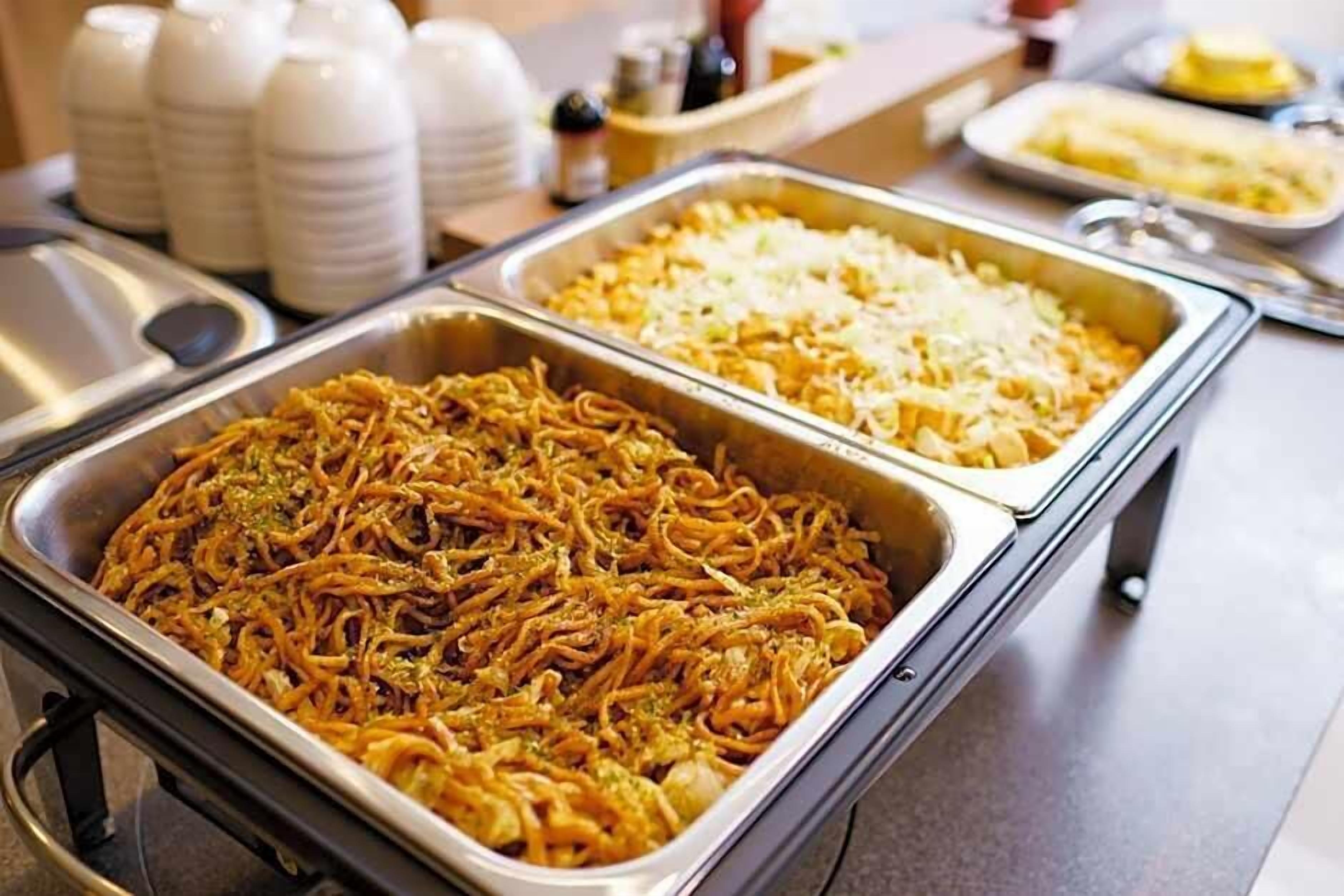 Buffet com massas e pratos de arroz.