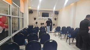A room with rows of blue chairs, a stage with balloons, and a 'Happy Birthday' sign. - Capital O 769 City Hotel (Balikpapan)