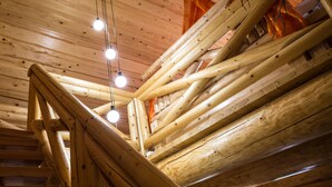 Ein Holzzimmer mit Treppe und hängenden Lampen.