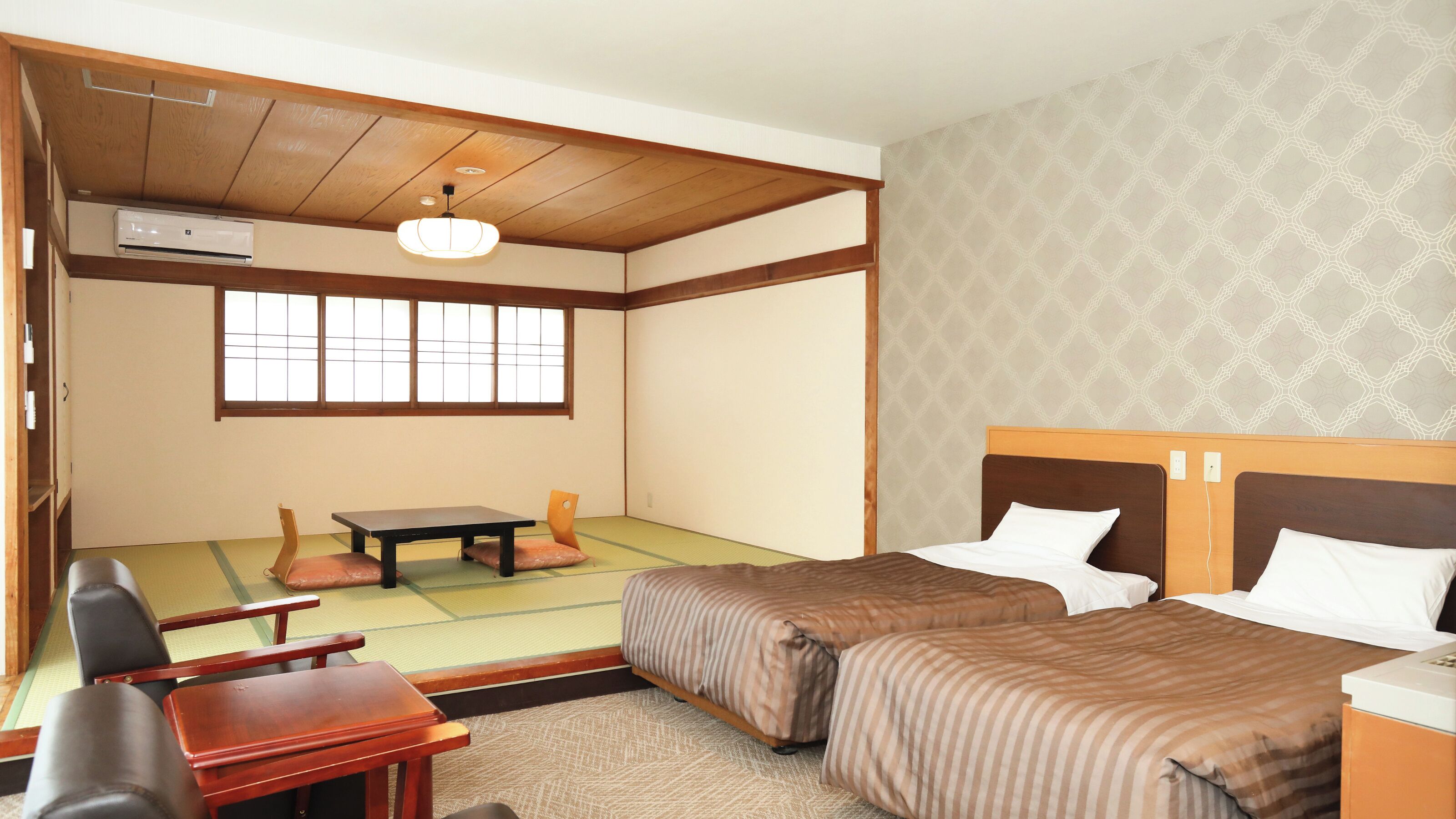 Una habitación japonesa tradicional con suelo de tatami, un futón, una mesa de madera baja y una ventana con pantalla shoji.