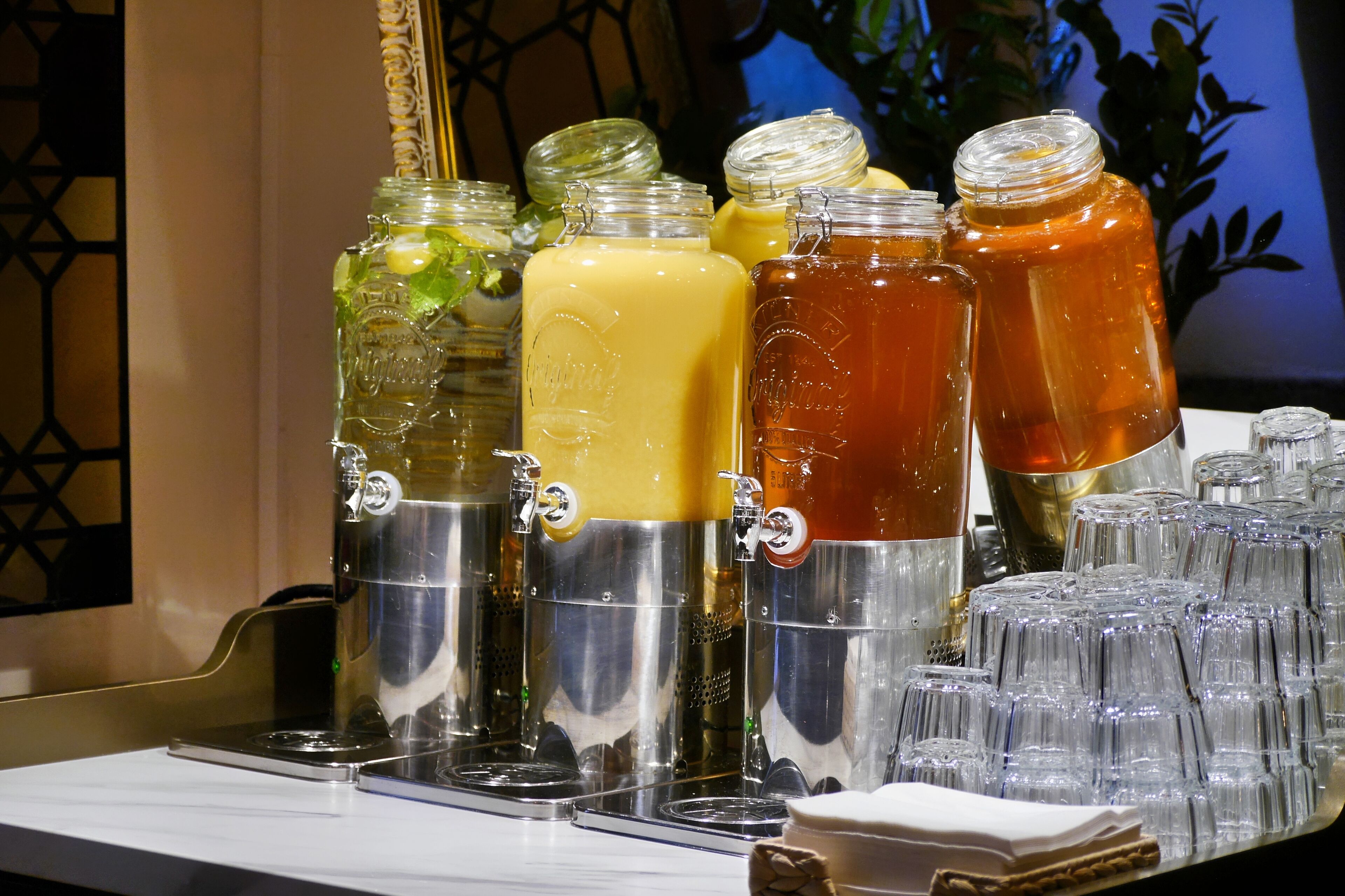 A beverage station with multiple dispensers filled with different drinks.