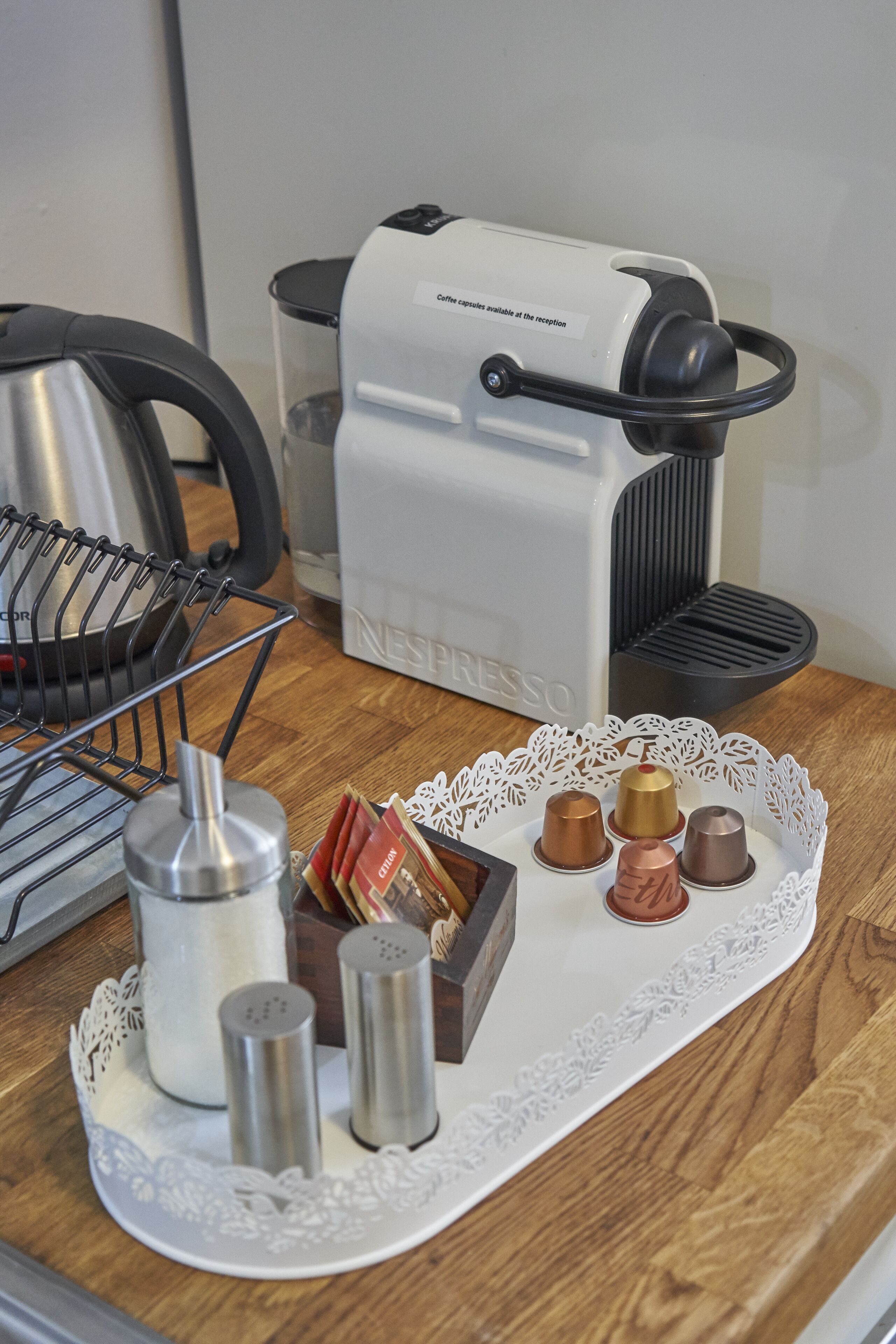 Een aanrecht met een koffiezetapparaat, zoutstrooiers en een houder voor koffiekapsules.