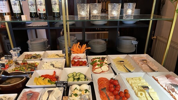 Buffet amb diverses opcions de menjar, incloent pasta, amanides, formatges i carns.