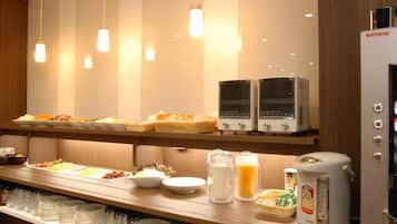 A buffet area with various food items, a coffee machine, and a refrigerator.