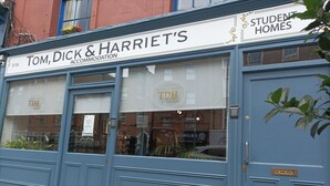A blue exterior of Tom, Dick & Harriet's accommodation with a signboard advertising student homes. - Tom Dick and Harriet's (Dublin)