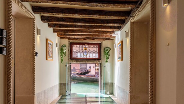 A corridor with a glass floor leading to a room with a gondola view. - Numa Venice Palazzo Orseolo (Venice)