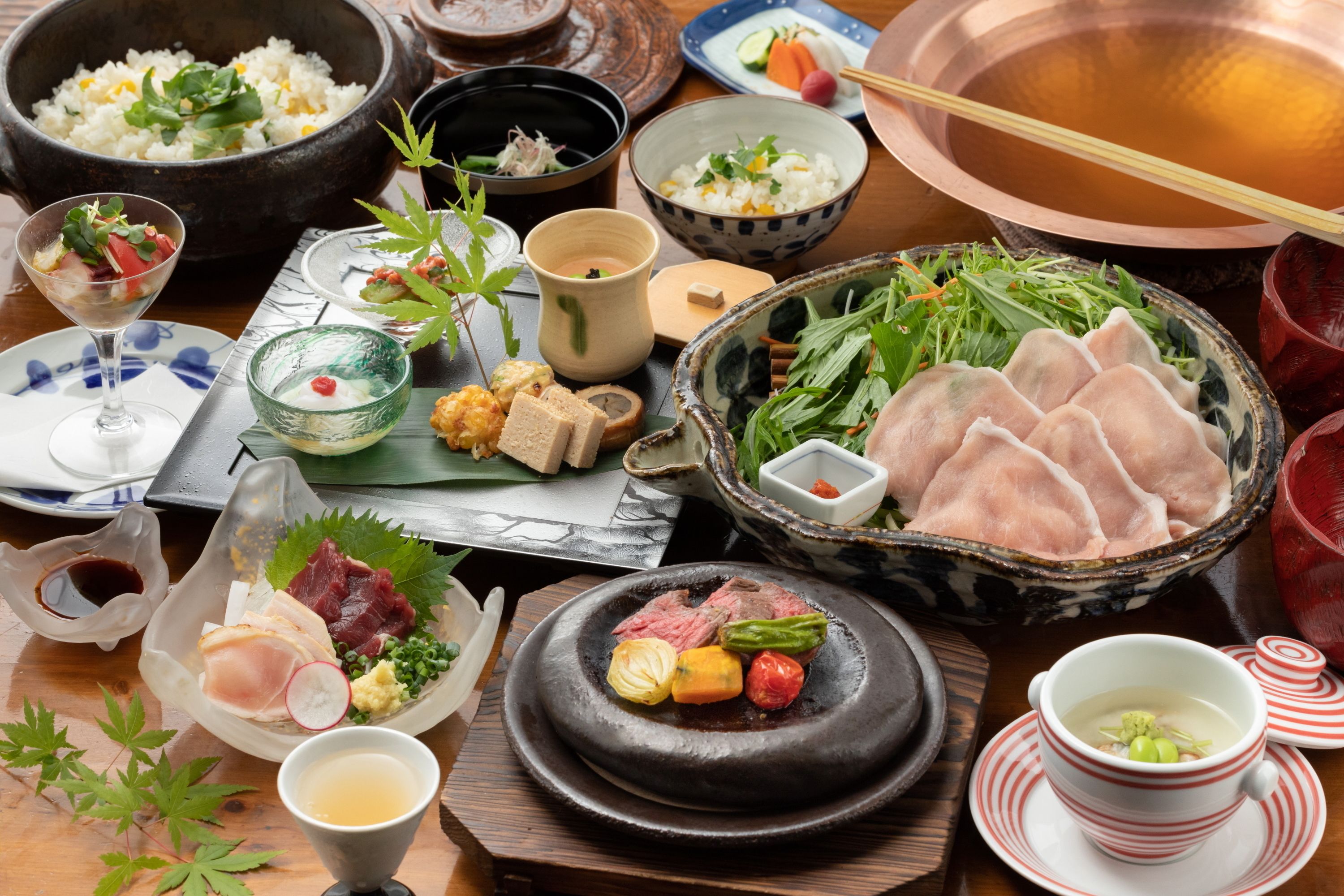 A variety of dishes including rice, vegetables, and meat, arranged on a wooden table.