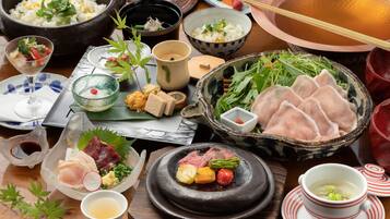 A variety of dishes including rice, vegetables, and meat, arranged on a wooden table.