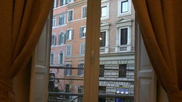 A room with a window overlooking a row of buildings. - Guest House Urbana (Rome)