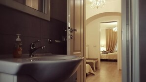 A modern bathroom with a large sink, a mirror, and a chandelier. - Guest House Urbana (Rome)