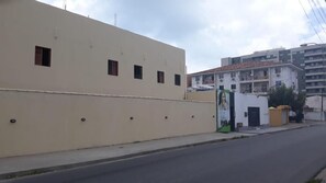 A beige building with multiple small windows and a gated entrance. - Pousada Praia Bela Maceio (Maceió)
